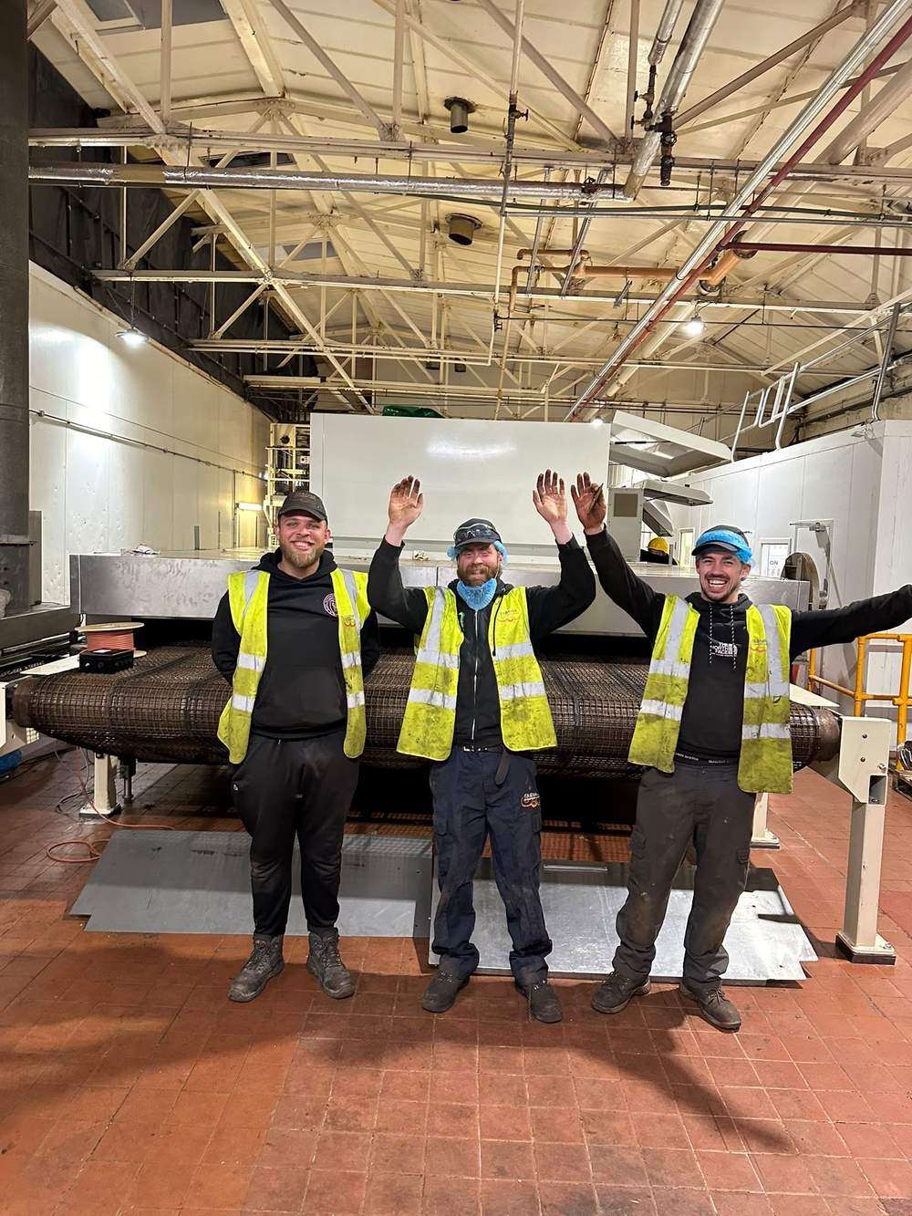 Three FABtekk engineers celebrating the completed band installation