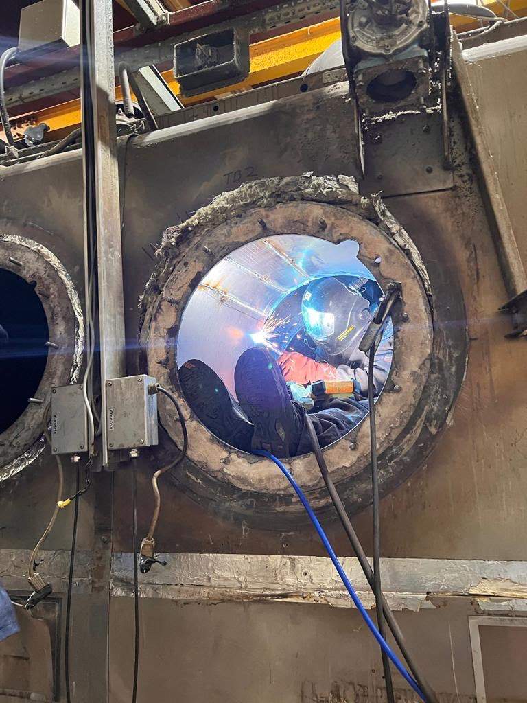 Engineer welding inside a burner tube