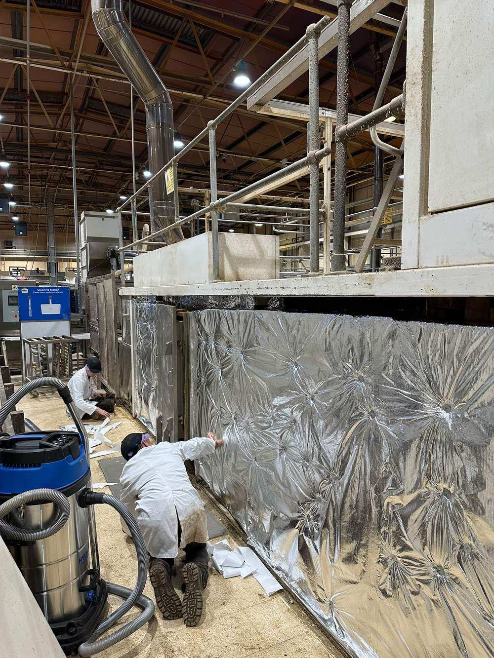 Engineers fitting foil cladding over the new insulation