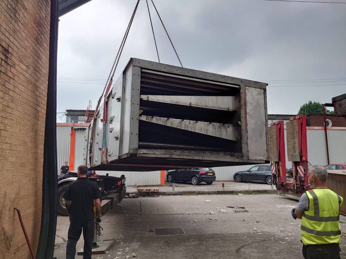 Oven section suspended from crane chains during lift out